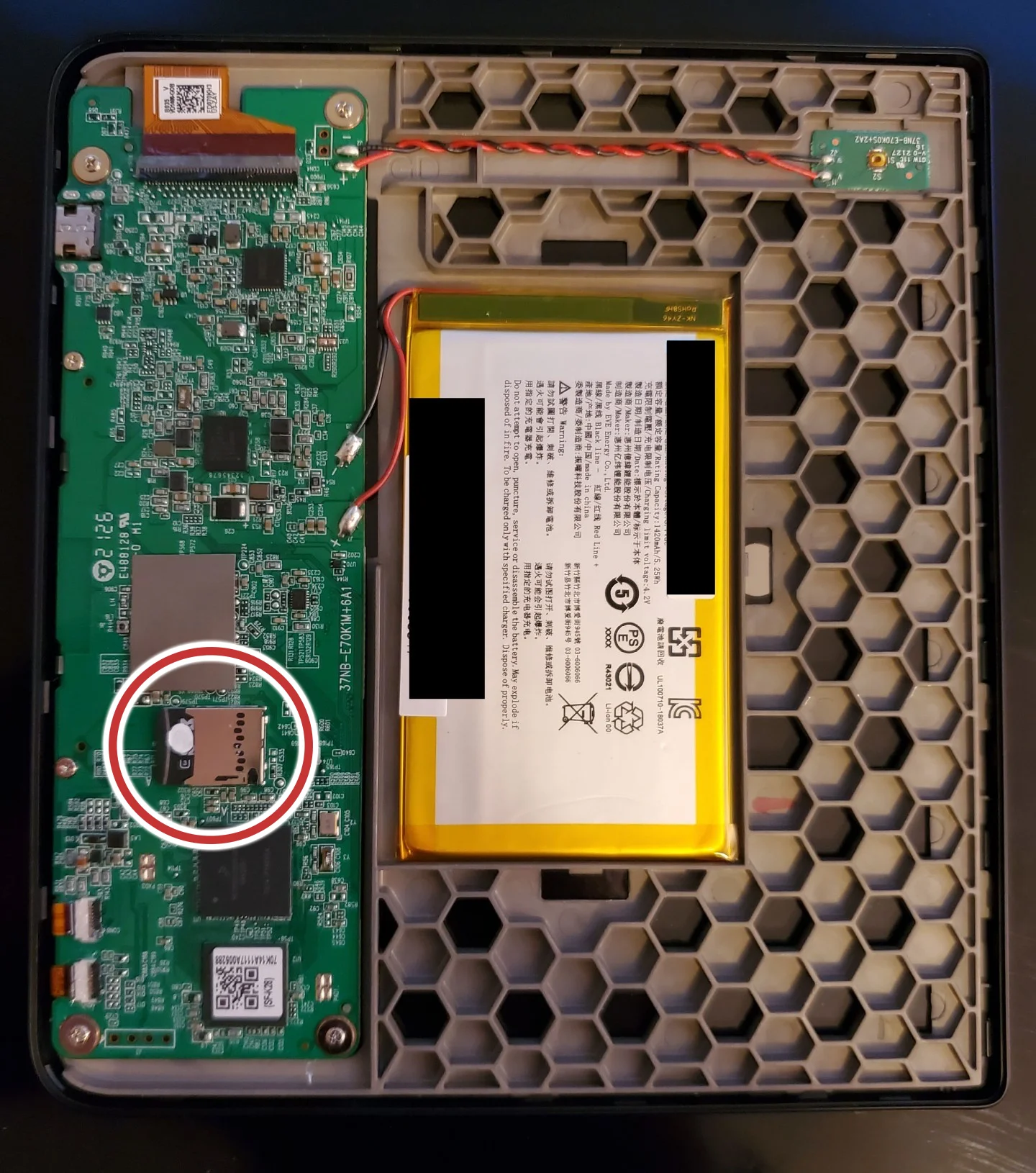 The opened back of a Kobo Libra 2 showing its circuit board, with the internal SD card slot circled in red.